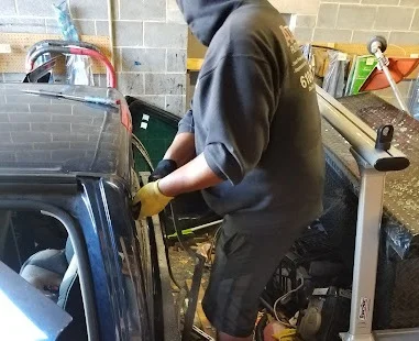 an auto glass technician repairs a rear windshield