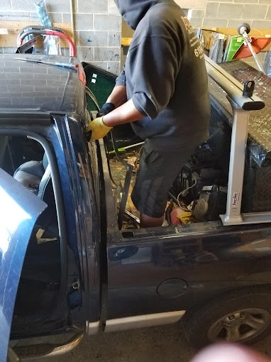 an autoglass technician repairs a rear windshield